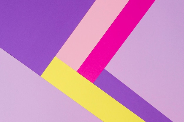 Fundo de composição plana de geometria de papéis coloridos com tons de amarelo rosa violeta roxo rosa