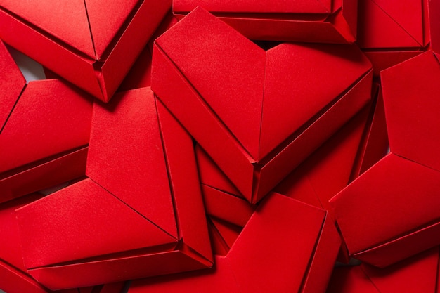 fundo de coração de papel vermelho, bando de cortar corações de papel rosa e vermelho sobre fundo vermelho.