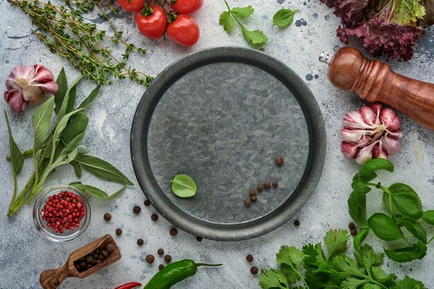 Fundo de cozimento de alimentos. Açafrão fresco, alho, coentro, manjericão, tomate cereja, pimentão e azeite, especiarias, ervas e vegetais na mesa de ardósia cinza claro. Vista superior de ingredientes alimentares.