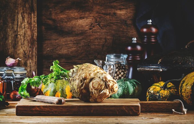 Fundo de cozimento de alimentos de outono com vegetais de fazenda orgânica, ervas de abóbora de aipo e especiarias na mesa de cozinha de madeira rústica com placa de corte de moedores de especiarias de panela de ferro fundido