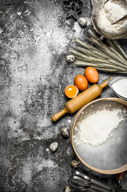 Fundo de cozimento. ingredientes e ferramentas para preparação de massa. sobre um fundo rústico.