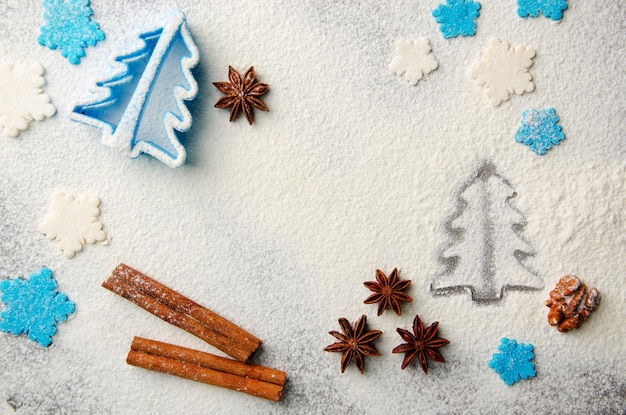 Fundo de cozinha de Natal feito de farinha, paus de canela, erva-doce, cortador de biscoitos e granulado de açúcar