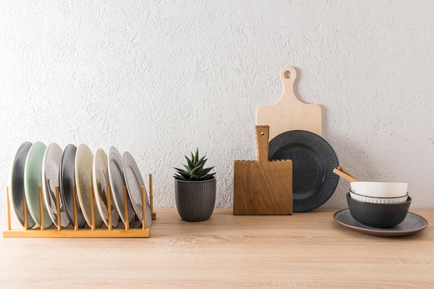 Fundo de cozinha em tampo de mesa de estilo minimalista com várias placas de corte tigelas flor em uma panela