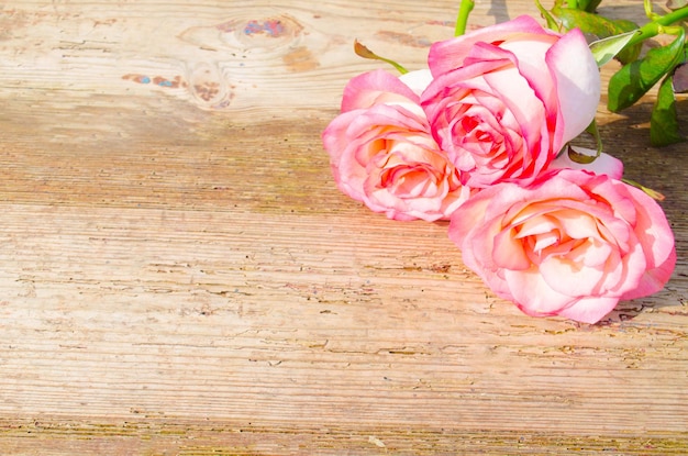 Fundo de dia dos namorados com rosas cor de rosa sobre a mesa de madeira copie o espaço