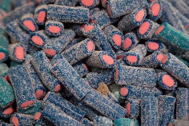 Fundo de doces de gelatina em borracha azuis e rosa cobertos com açúcar closeup