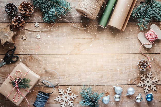 Fundo de embrulho de presente de Natal com papel kraft, corda de juta, tesoura e galhos de pinheiro