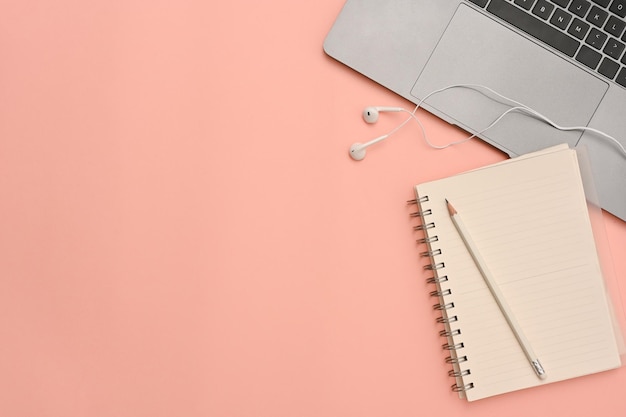 Fundo de espaço de trabalho rosa pastel mínimo com lápis de diário de fones de ouvido de computador portátil e espaço de cópia