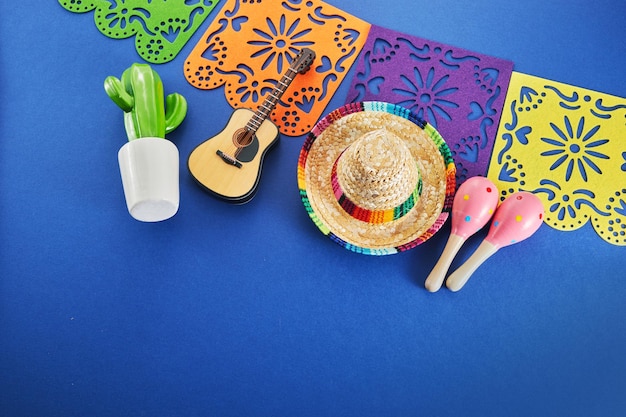 Fundo de feriado de cinco de maio maracas cacto e chapéu em fundo azul