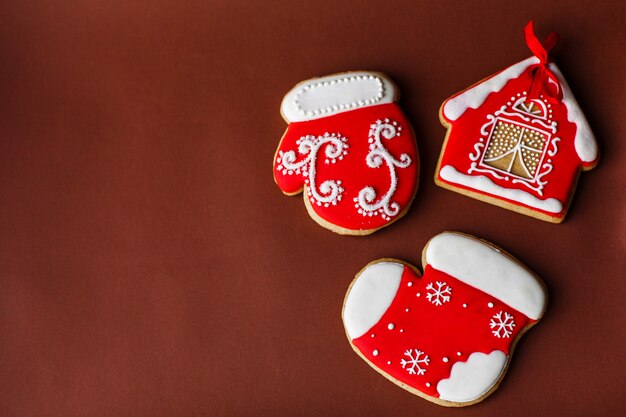 Fundo de férias de ano novo de Natal, biscoitos de gengibre vermelho e cones na mesa vermelha escura. Copie o espaço