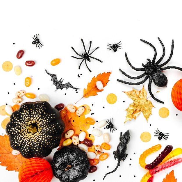Fundo de férias de halloween com doces coloridos, morcegos, aranhas, abóboras e decorações. postura plana. vista de cima