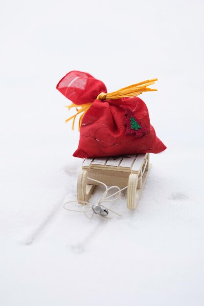 Fundo de férias de inverno: mini saco vermelho com presentes de Natal em trenós de madeira. Fechar-se