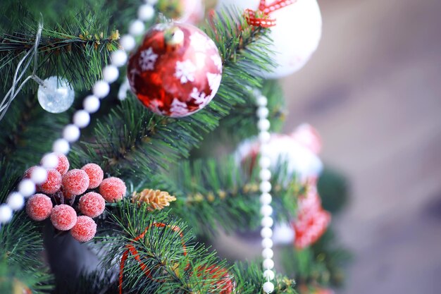 Fundo de férias de Natal. Bugiganga de prata e cor pendurada em uma árvore decorada com bokeh e neve, copie o espaço.