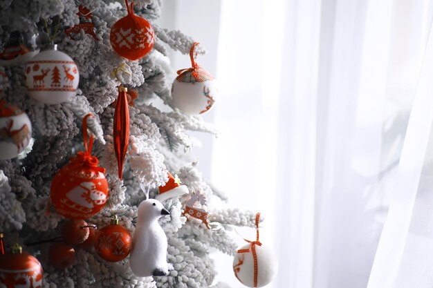 Fundo de férias de Natal. Bugiganga prateada e colorida pendurada em uma árvore decorada com bokeh e neve, copie o espaço.
