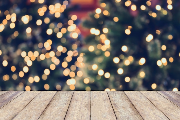 Fundo de férias de Natal com tampo de mesa de madeira vazio sobre luz festiva bokeh decorar na árvore de Natal. Para criar exibição de produto de montagem