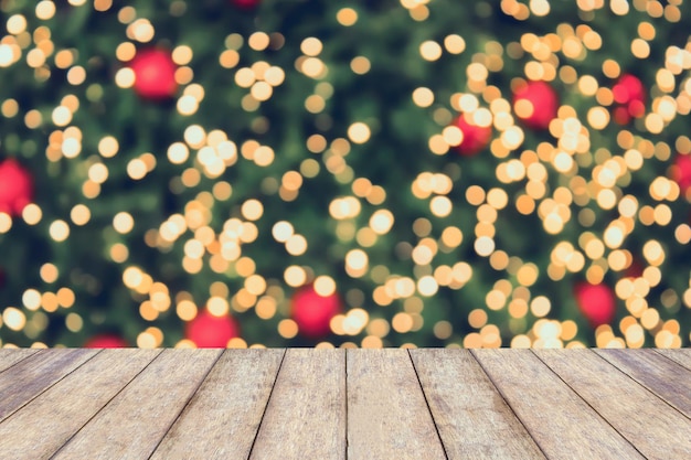 Fundo de férias de Natal com tampo de mesa de madeira vazio sobre luz festiva bokeh decorar na árvore de Natal. Para criar exibição de produto de montagem