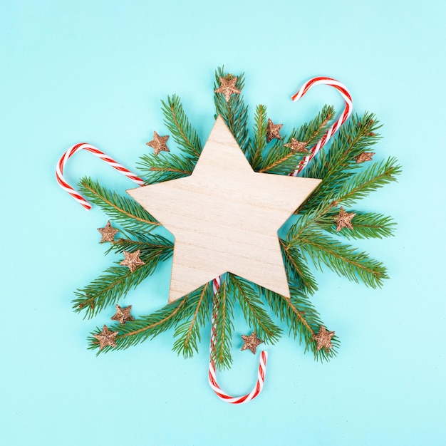 Fundo de férias de natal com uma estrela, moldura com ramos de abeto, pinhas e cana-de-doce