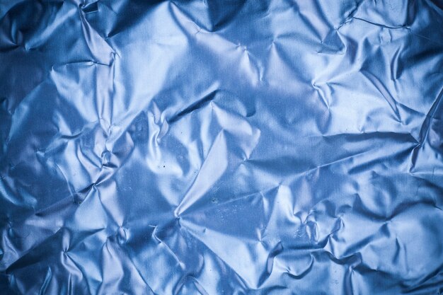 Fundo de folha de alumínio azul amassado.
