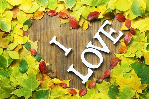 Fundo de folhas de outono em forma de coração na mesa de madeira