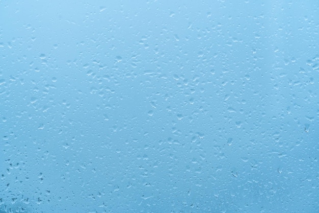 Fundo de gotas de água Gotas de chuva na janela fundo azul Gotas de chuva Água ao amanhecer com luz azul sobre fundo de vidro Fundo azul gotas de textura abstrata de vidro