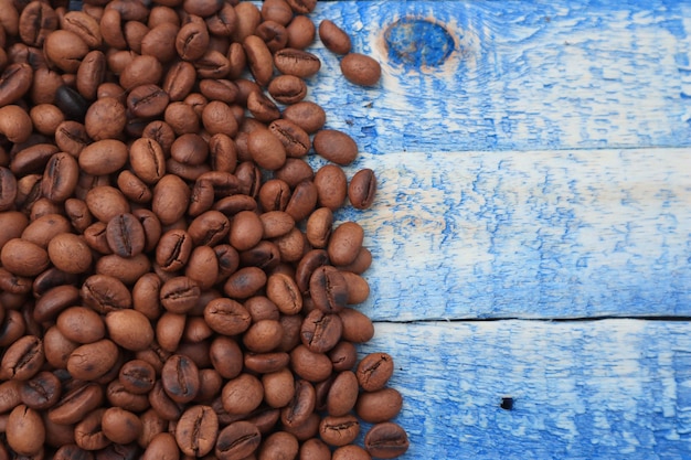 Fundo de grãos de café torrados em placa de madeira azul com espaço de cópia