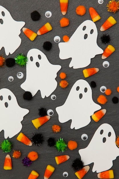 Fundo de Halloween com fantasmas e milho doce em um fundo de ardósia