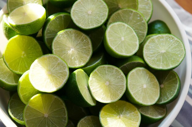Foto fundo de limão com luz solar de fora em close-up de limões foco seletivo de limão cortado