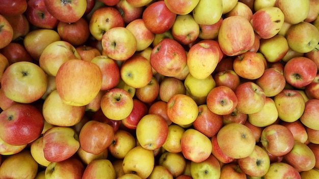 Fundo de maçãs amarelas vermelhas na pilha de frutas frescas de maçã