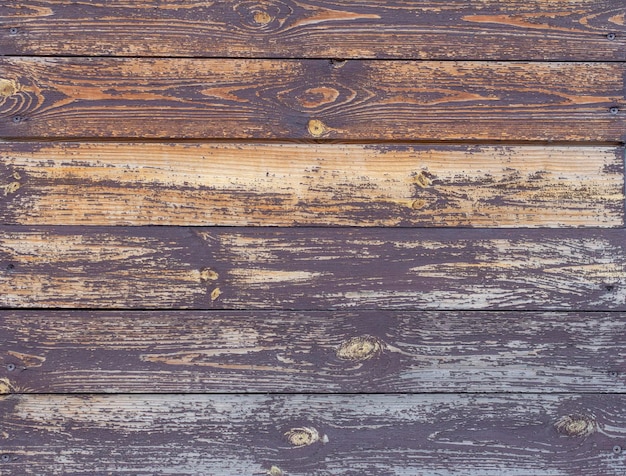 Fundo de madeira. A textura de uma velha parede de madeira com tinta marrom rachada.