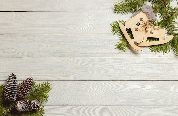 Fundo de madeira branco do Natal com ramos de abeto, cones, decoração, vista superior, copyspace.