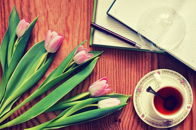 Fundo de madeira com tulipa e chá