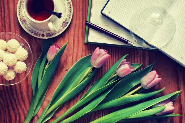 Fundo de madeira com tulipa e chá