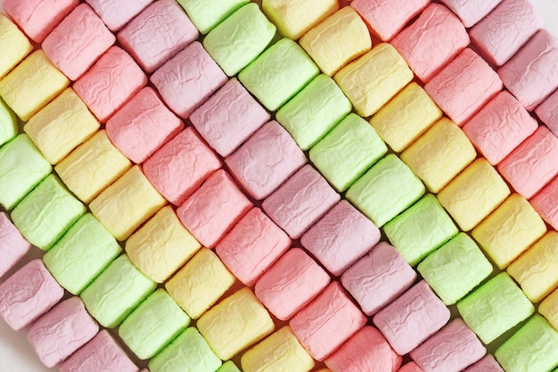 Fundo de marshmallow colorido brilhante. Linhas diagonais de marshmallows. Padrão geométrico de doces macios.