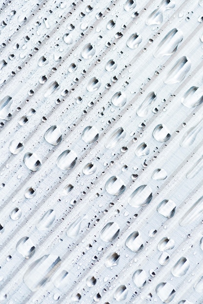 Fundo de material metálico listrado branco com gotas de chuva