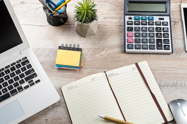 fundo de mesa de escritório com laptop vazio bloco de notas calculadora de caneta e suprimentos fundo de negócios de vista superior