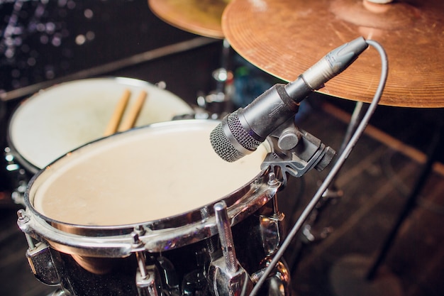 Fundo de música ao vivo em tons vintage, baterista toca com baquetas na bateria de rock