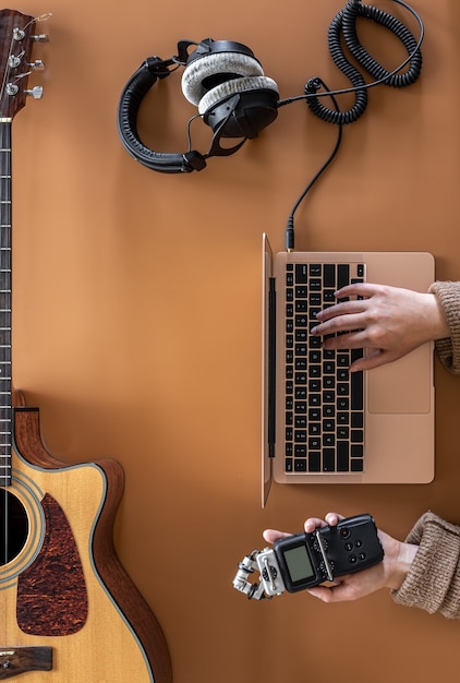 Fundo de música com fones de ouvido, laptop e guitarra, plana leigos.
