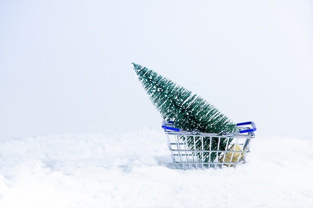 Fundo de Natal, árvore de Natal no carrinho de compras na neve branca