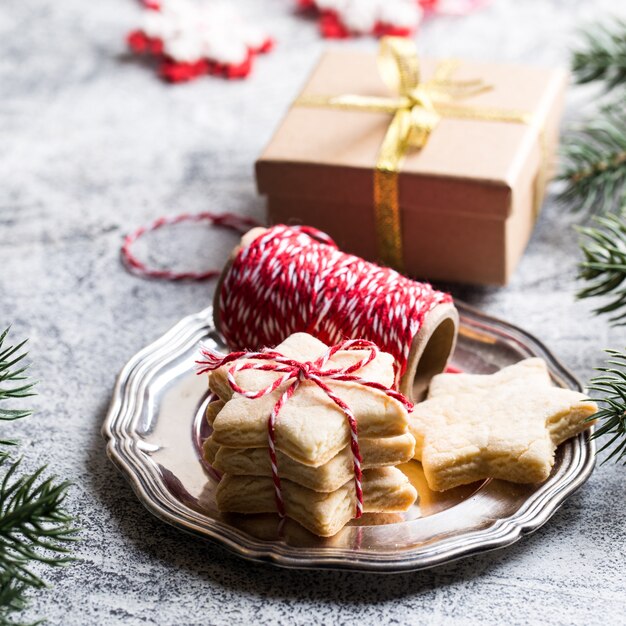 Fundo de natal. biscoito de gengibre festivo com fita, ramos de pinheiro