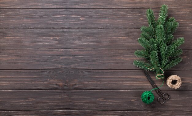 Fundo de Natal. Bouquet de ramos de abeto amarrados com barbante em uma mesa de madeira. Bandeira.