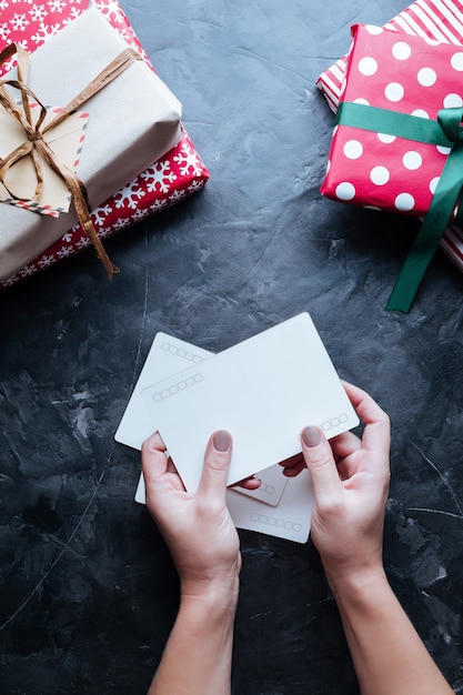 Fundo de natal. Caixas com presentes nas mãos no escuro