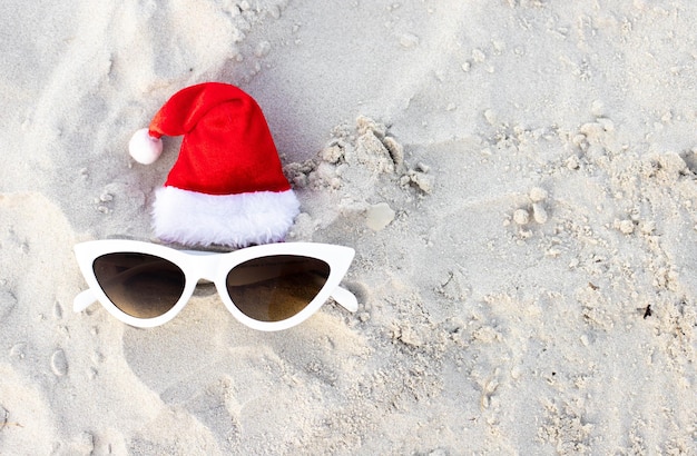 Fundo de Natal chapéu de Papai Noel na praia e óculos de sol