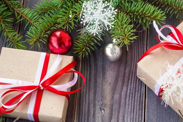 Fundo de Natal com árvore do abeto e decorações e caixas de presente na placa de madeira.