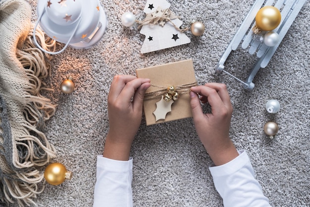 Fundo de natal com atmosfera aconchegante de inverno As mãos das crianças abrem um presente de ano novo