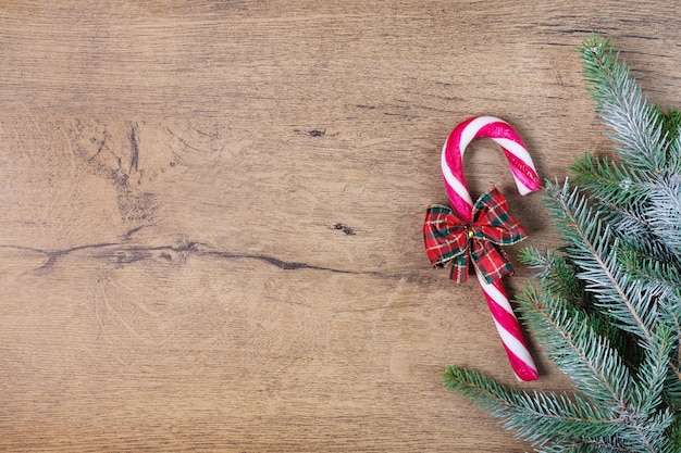 Fundo de Natal com bastões de doces e árvore de Natal na placa de madeira. cartão de natal