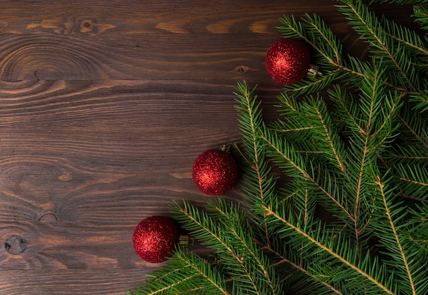 Fundo de natal com galhos de pinheiro e decorações na mesa de madeira velha marrom. espaço para texto ou desenho. vista do topo.