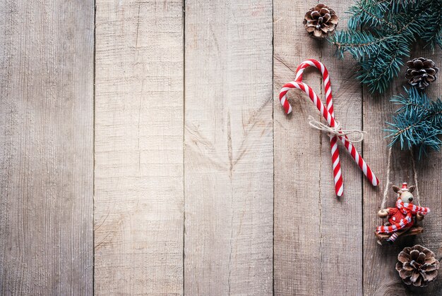 Fundo de Natal com galhos de pinheiros, luzes de Natal e uma mini figura de rena com chapéu e lenço de Papai Noel