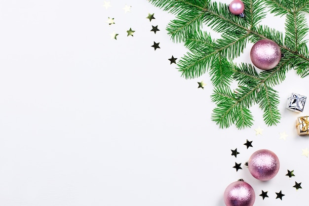 Fundo de Natal com galhos de pinheiros, luzes de Natal, enfeites rosa e bege, enfeites de prata