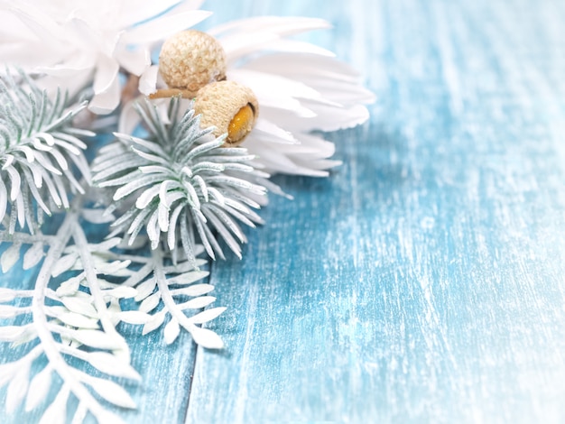 Fundo de Natal com ramos de abeto branco e flocos de neve em um fundo azul de madeira