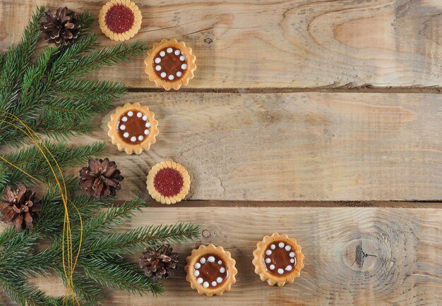 Fundo de Natal com ramos de abeto e cones com biscoitos