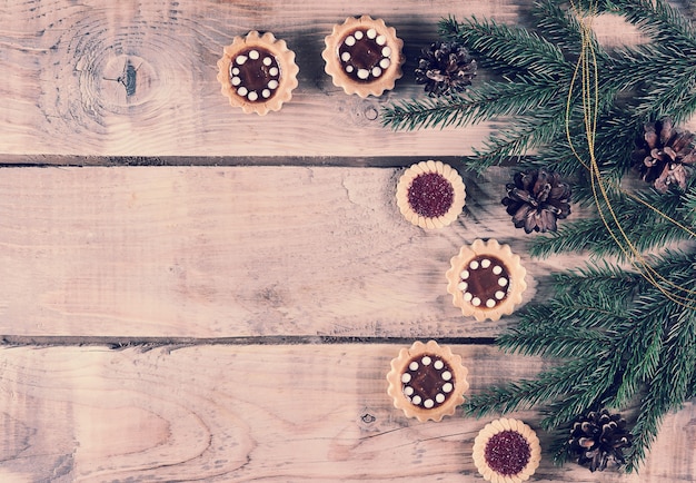 Fundo de natal com ramos de abeto e cones com biscoitos